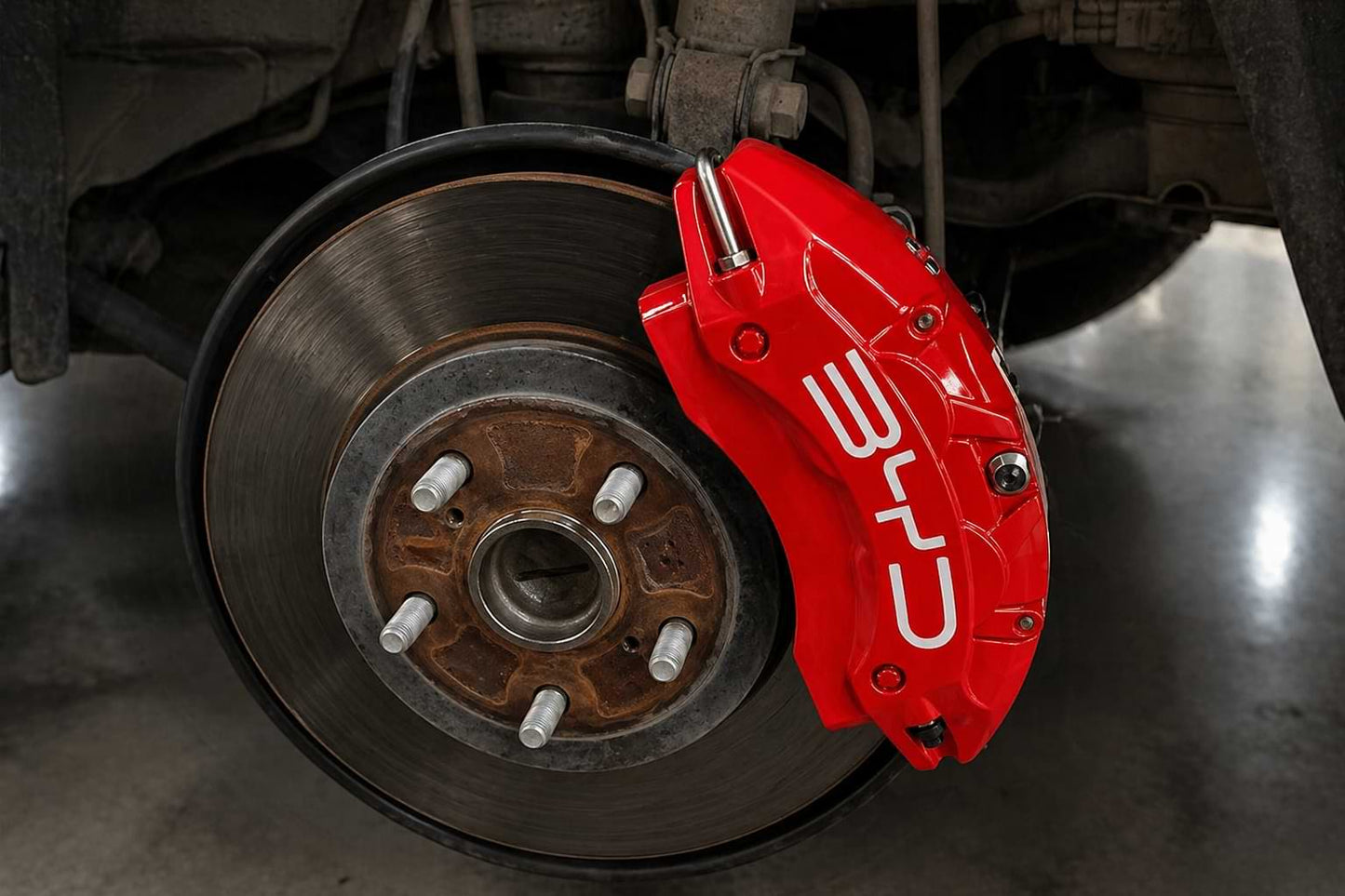 Close-up of a red brake caliper on a vehicle's wheel byd atto 3
