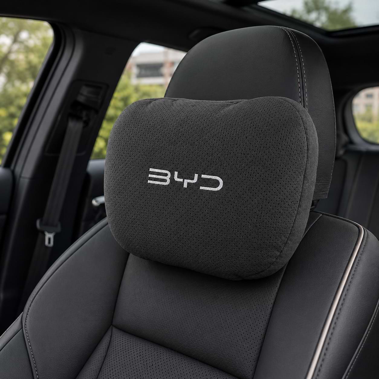 Car headrest pillow with BYD logo inside a vehicle