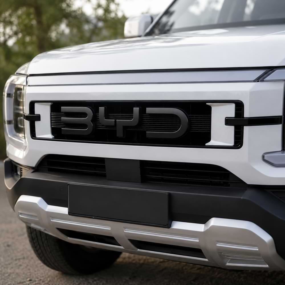 Close-up of a white BYD vehicle with the brand logo on the grille.