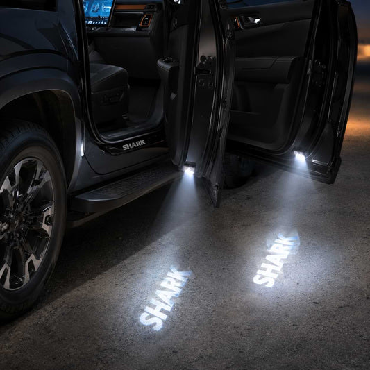 BYD Shark 2025 LED door welcome light projecting Shark logo onto the ground at night